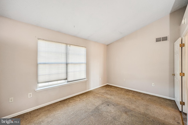 empty room with visible vents, baseboards, carpet, and lofted ceiling