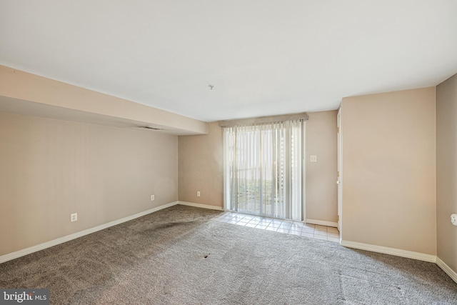 carpeted spare room featuring baseboards