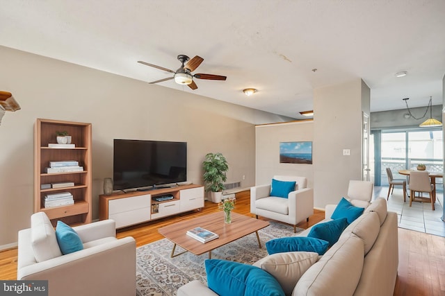 living room with visible vents, baseboards, wood finished floors, and a ceiling fan