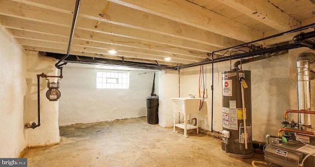 basement featuring gas water heater and a sink