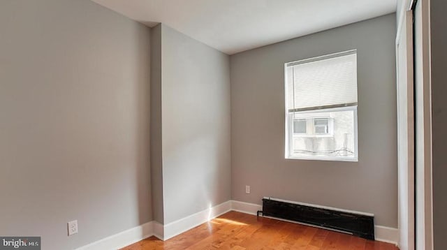 empty room featuring light wood-type flooring and baseboards