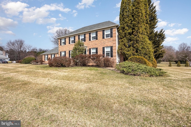 colonial house with brick siding and a front yard