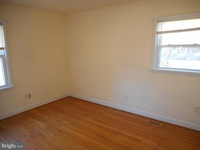 unfurnished room featuring baseboards, visible vents, and light wood-type flooring