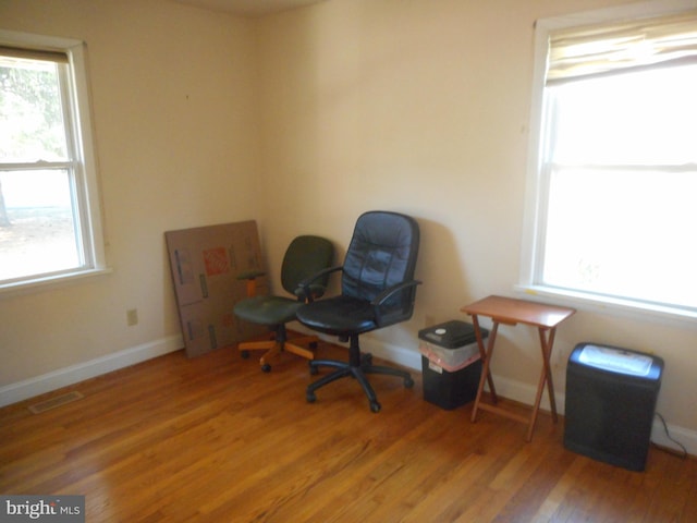 sitting room featuring visible vents, baseboards, and wood finished floors