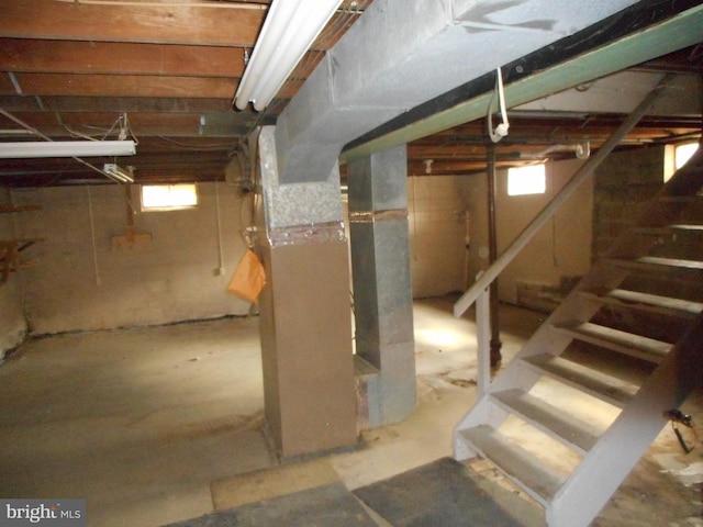 basement featuring heating unit and stairs