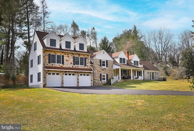 view of front of property featuring aphalt driveway, stone siding, an attached garage, and a front lawn