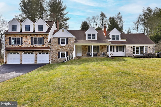 view of front of property with a chimney, driveway, an attached garage, and a front lawn