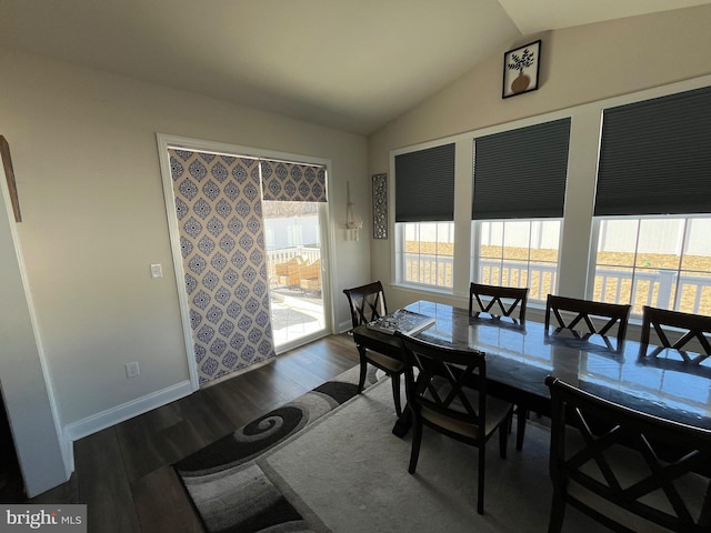 dining room with lofted ceiling, baseboards, and dark wood-style flooring