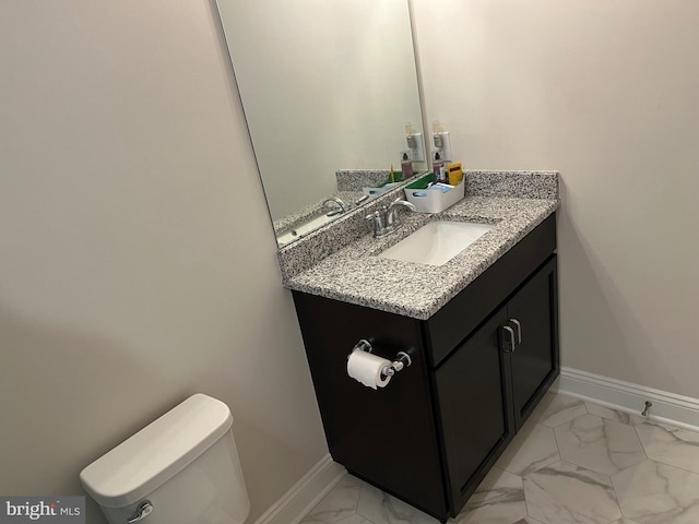 half bathroom featuring vanity, toilet, baseboards, and marble finish floor