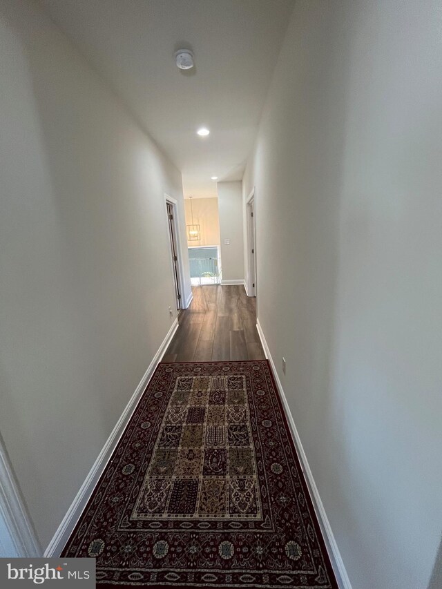 hall featuring recessed lighting, wood finished floors, and baseboards