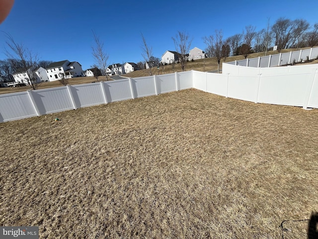 view of yard with a residential view and a fenced backyard