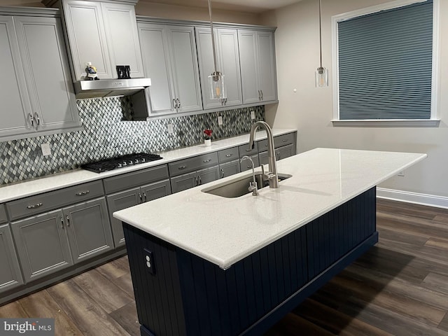 kitchen with dark wood-style floors, gray cabinets, gas stovetop, and a sink