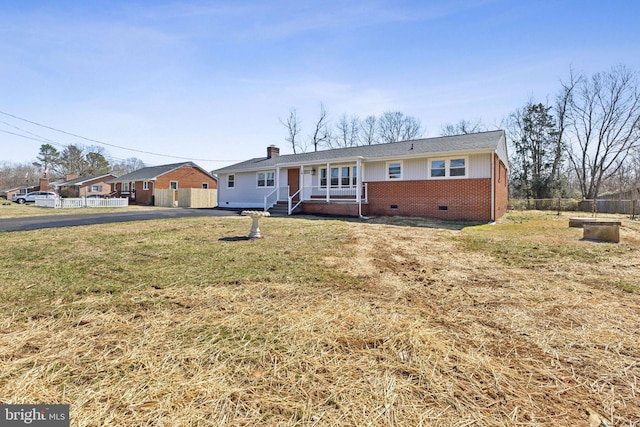 single story home with brick siding, fence, a front yard, a chimney, and crawl space