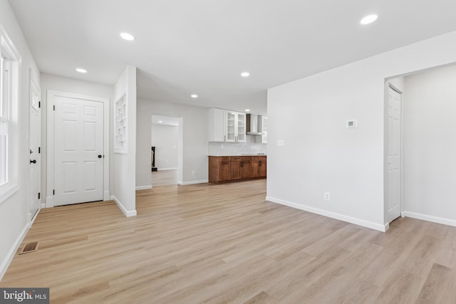 unfurnished living room with recessed lighting, light wood-style floors, visible vents, and baseboards