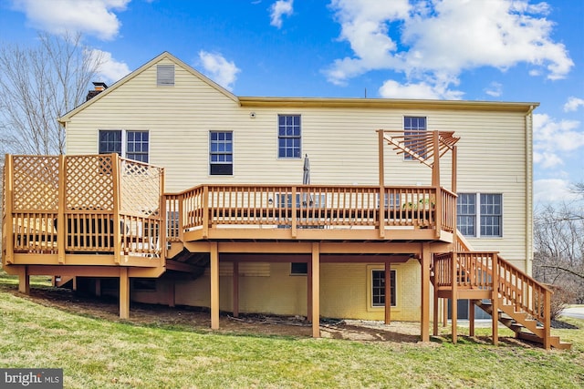 back of property featuring a chimney, stairway, a wooden deck, and a yard