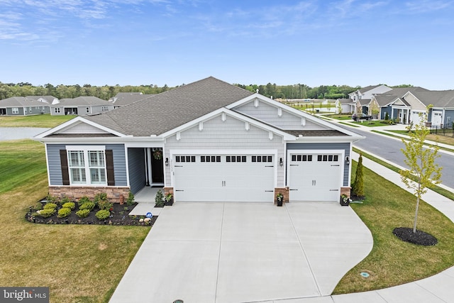 craftsman inspired home with an attached garage, a shingled roof, a front lawn, and concrete driveway