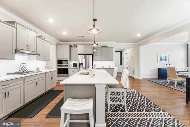 kitchen with a sink, gray cabinets, under cabinet range hood, and stainless steel appliances