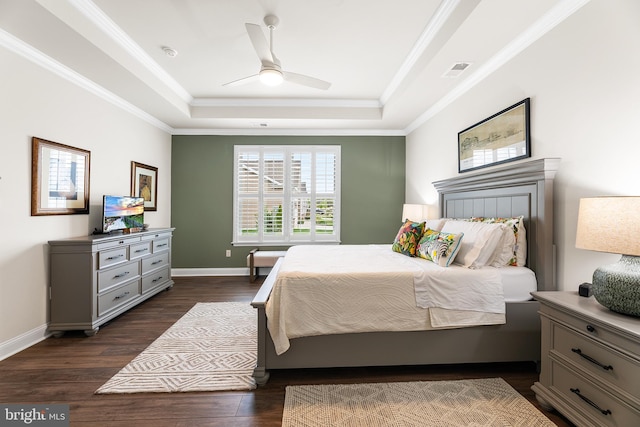 bedroom featuring visible vents, crown molding, baseboards, dark wood finished floors, and a raised ceiling