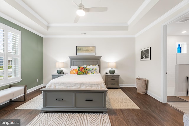 bedroom with visible vents, crown molding, baseboards, dark wood-type flooring, and a raised ceiling