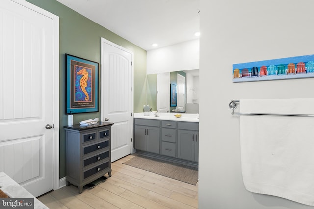 bathroom with recessed lighting, vanity, and wood finished floors