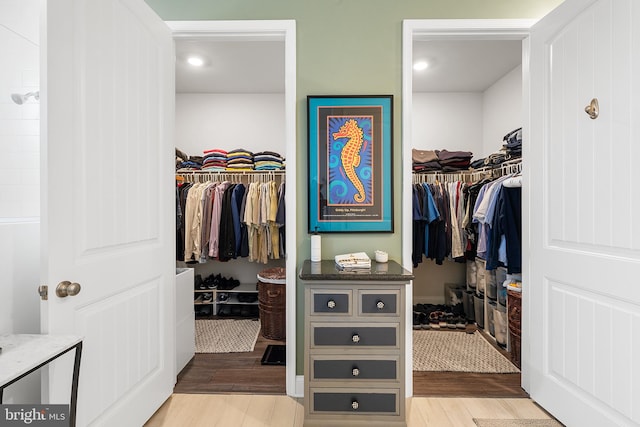 walk in closet with light wood-style floors