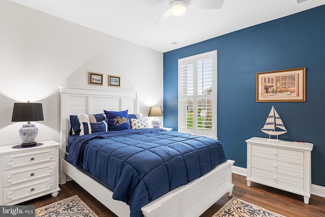 bedroom with dark wood finished floors, visible vents, a ceiling fan, and baseboards