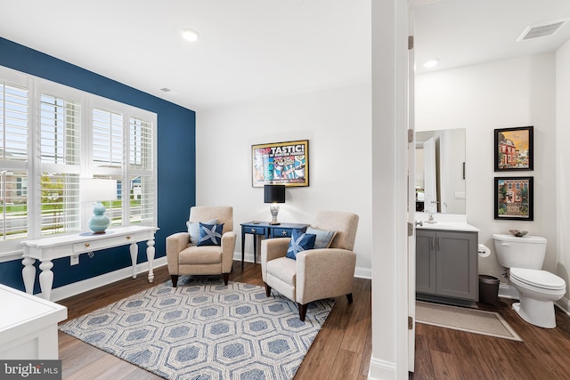 sitting room featuring visible vents, baseboards, and wood finished floors