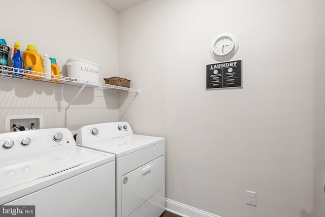 laundry area with baseboards, separate washer and dryer, and laundry area