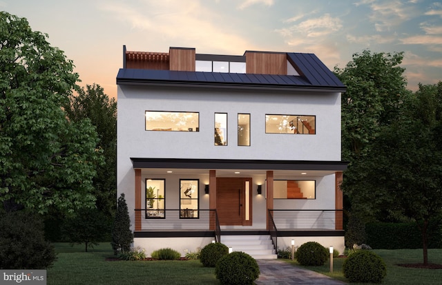 contemporary home with stucco siding, a porch, metal roof, and a standing seam roof