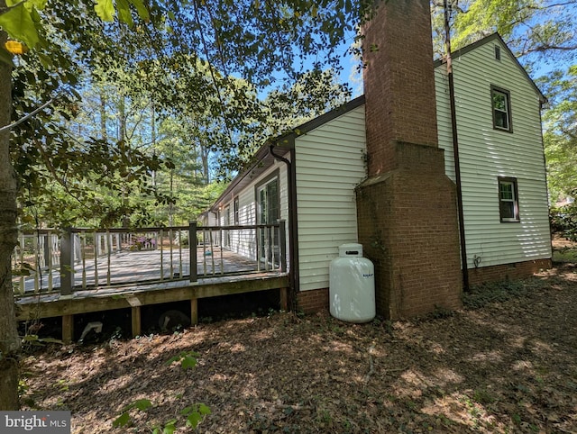 view of home's exterior featuring a chimney, crawl space, and a deck