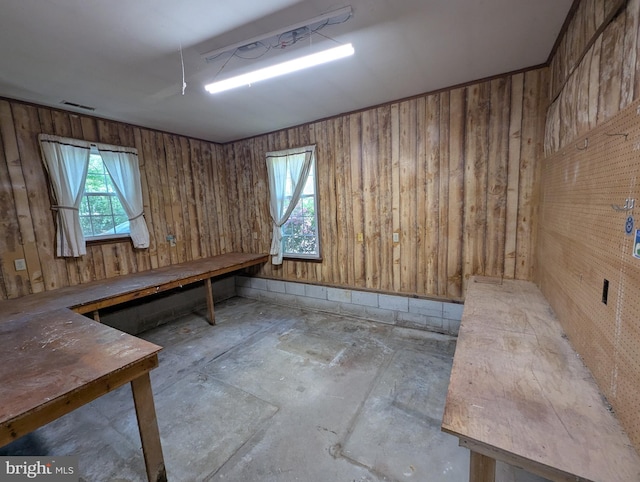 interior space featuring wood walls, visible vents, and concrete floors