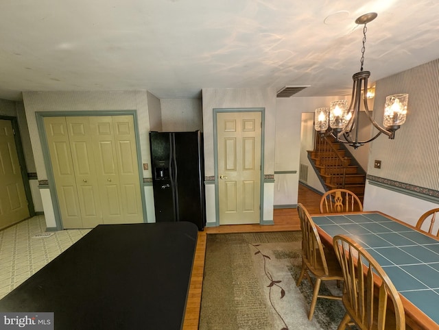 dining space featuring an inviting chandelier, stairs, and visible vents