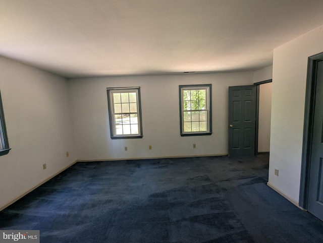 empty room featuring carpet floors and baseboards