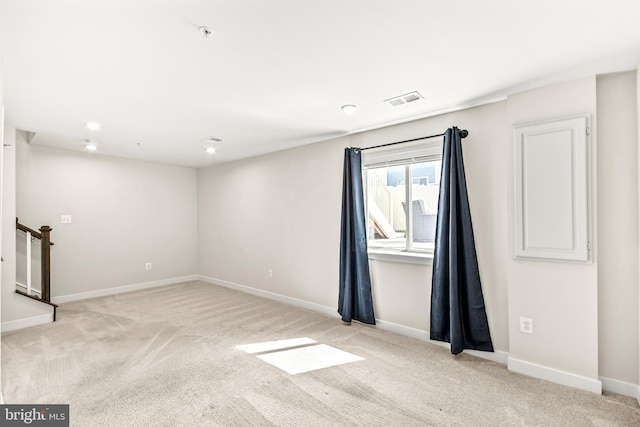 unfurnished room with carpet flooring, visible vents, and baseboards