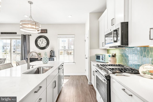 kitchen featuring a sink, plenty of natural light, appliances with stainless steel finishes, and light countertops