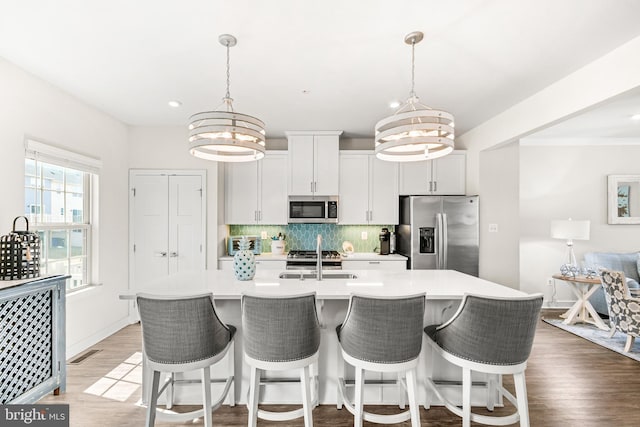 kitchen with a sink, tasteful backsplash, a chandelier, and stainless steel appliances