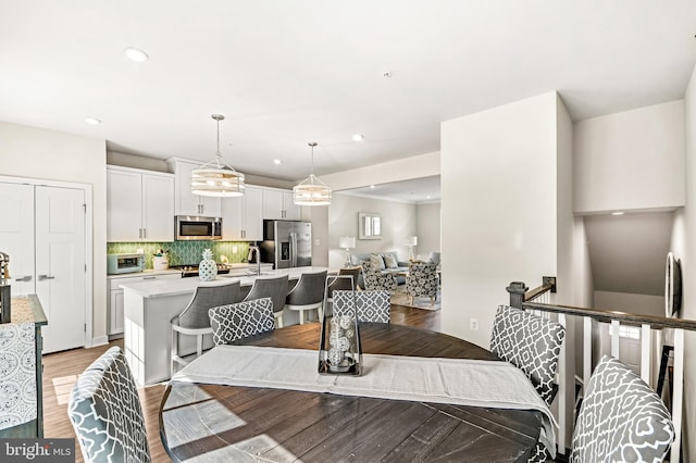 dining room with recessed lighting, light wood-type flooring, and a toaster