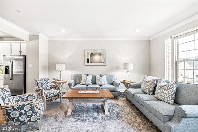 living room featuring wood finished floors, baseboards, and ornamental molding