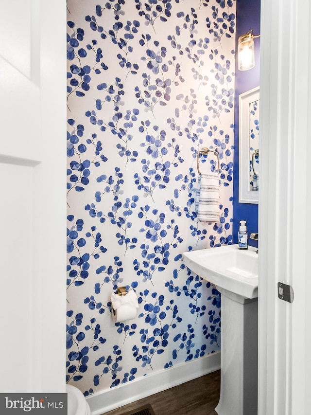 bathroom featuring a sink, baseboards, and wood finished floors