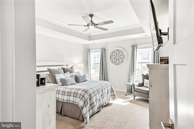 bedroom featuring a raised ceiling, multiple windows, light colored carpet, and baseboards