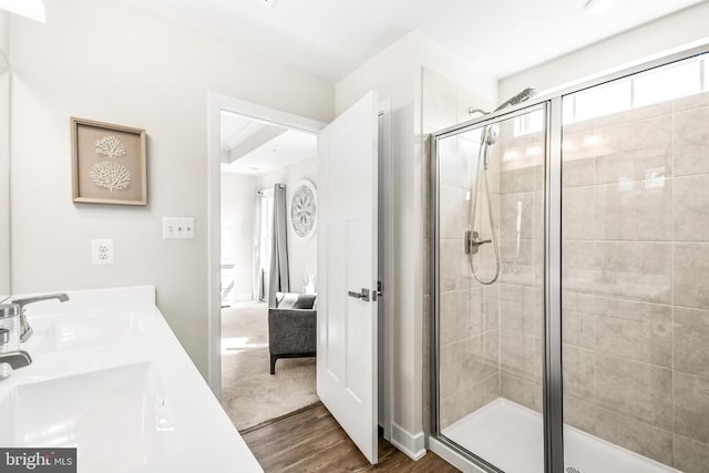 full bathroom with a sink, a shower stall, connected bathroom, and wood finished floors