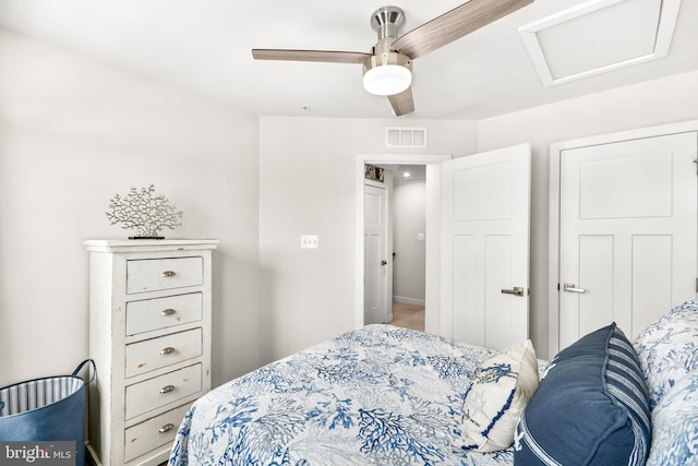 bedroom featuring attic access, visible vents, and ceiling fan