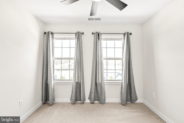 unfurnished room with carpet flooring, a healthy amount of sunlight, visible vents, and ceiling fan