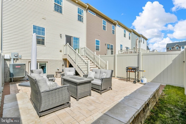 view of patio featuring outdoor lounge area, area for grilling, stairs, and fence private yard