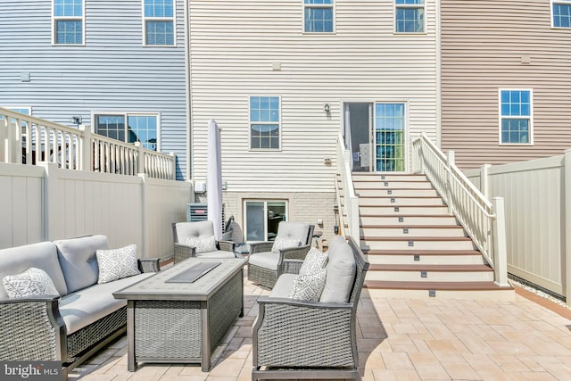 view of patio featuring stairway, outdoor lounge area, and fence