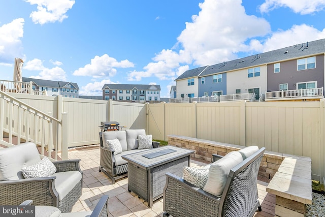 view of patio / terrace with a residential view, an outdoor living space with a fire pit, and a fenced backyard