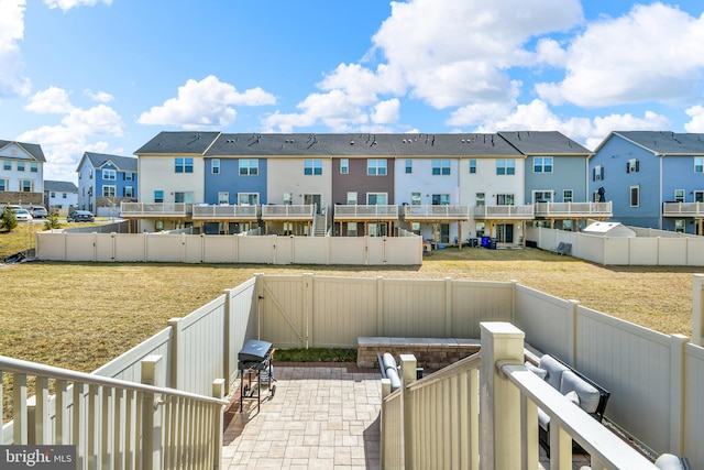 view of yard featuring a patio area, a residential view, a fenced backyard, and a gate