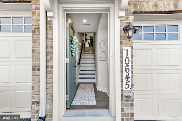 entrance to property featuring visible vents and stone siding