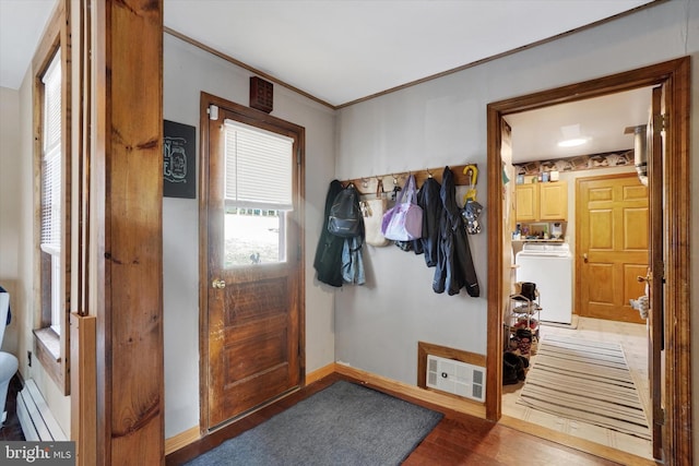 entryway featuring visible vents, ornamental molding, wood finished floors, a baseboard radiator, and baseboards