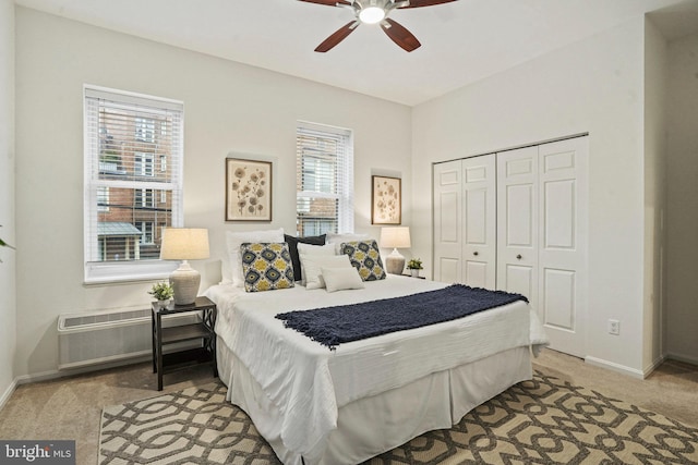 bedroom featuring an AC wall unit, a closet, carpet flooring, baseboards, and ceiling fan